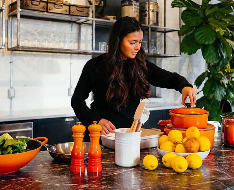 Personne préparant des légumes et des fruits sur un plan de travail