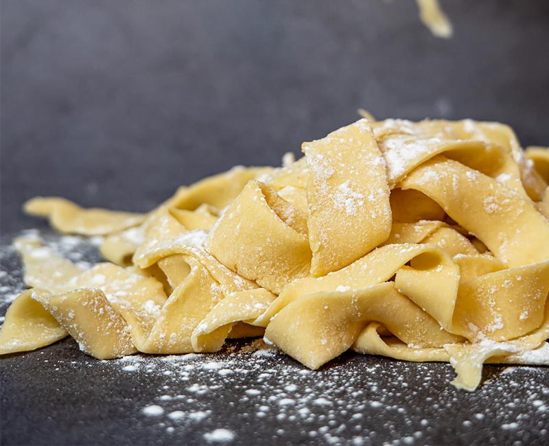 Larges rubans de pappardelle saupoudrés de farine