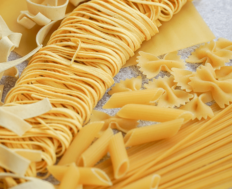 Pâtes longues sèches et farfalle disposées ensemble