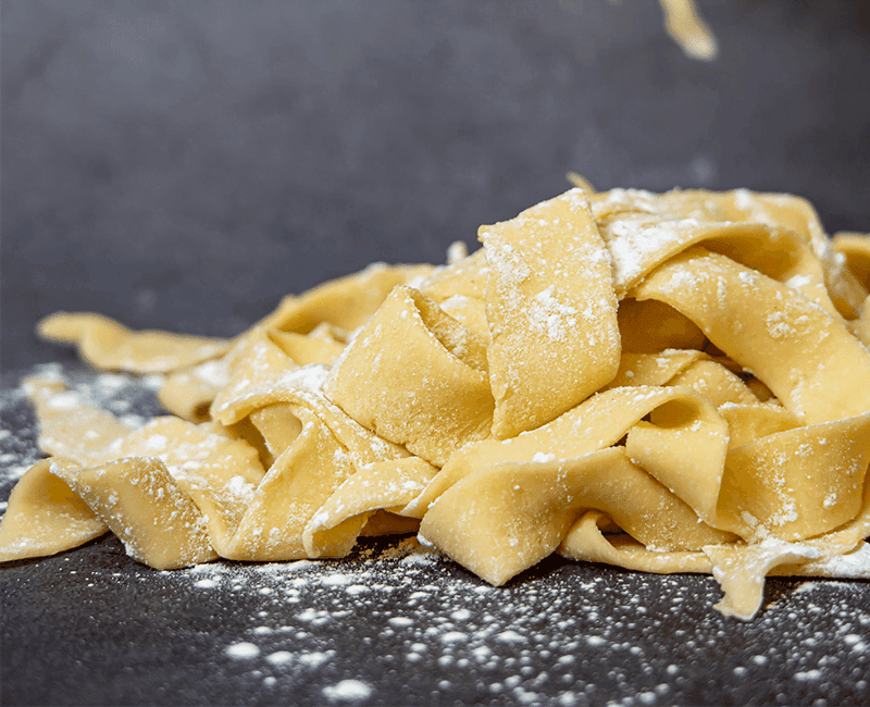 Larges rubans de pappardelle saupoudrés de farine