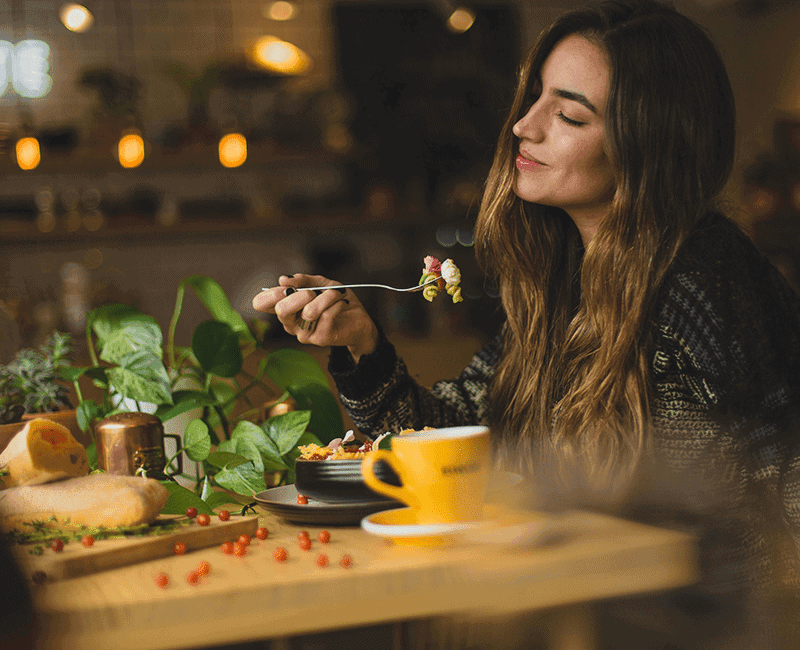 Personne mangeant un plat de pâtes au restaurant