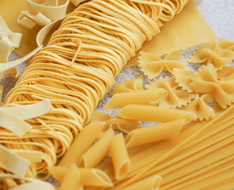 Pâtes longues sèches et farfalle disposées ensemble