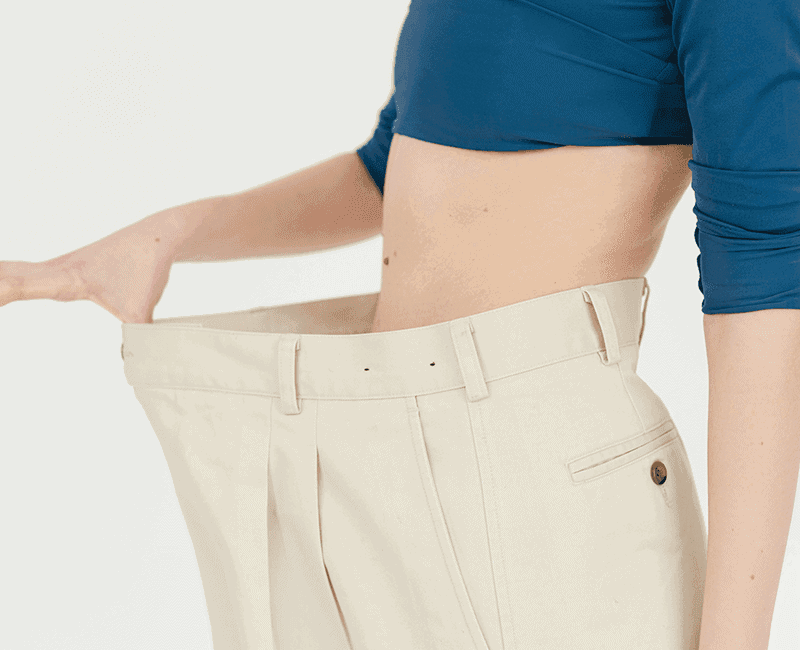 Personne tenant la ceinture d’un pantalon devenu trop large